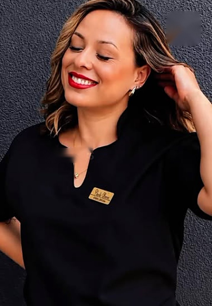 Carla Viana sorrindo, de uniforme preto do studio